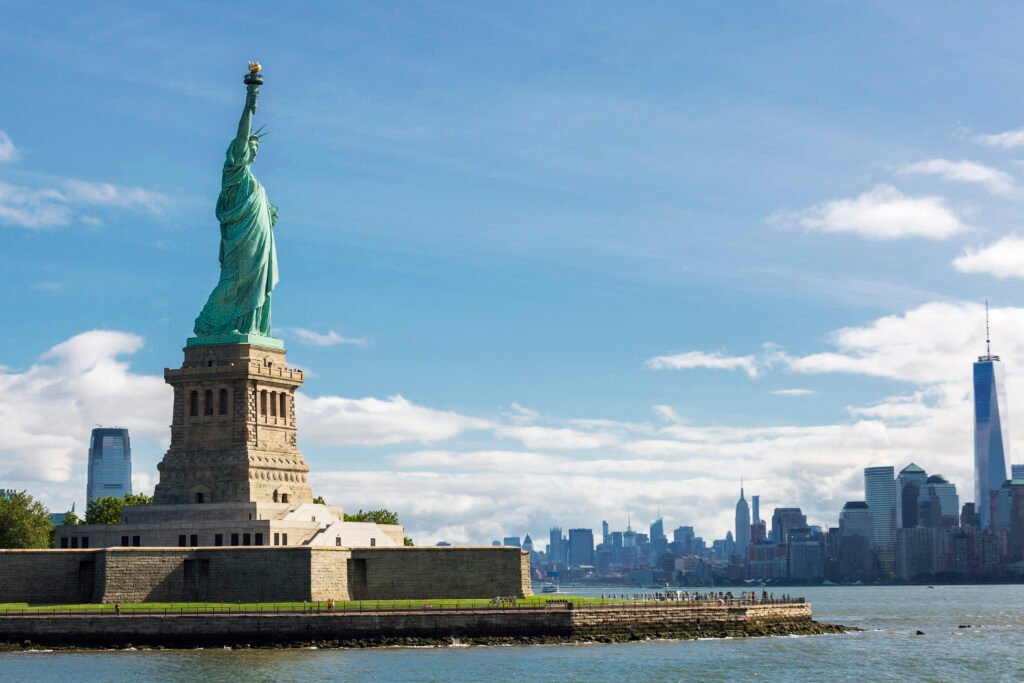 Estátua da Liberdade em Nova York com skyline ao fundo, representando viagens internacionais para os Estados Unidos em 2026