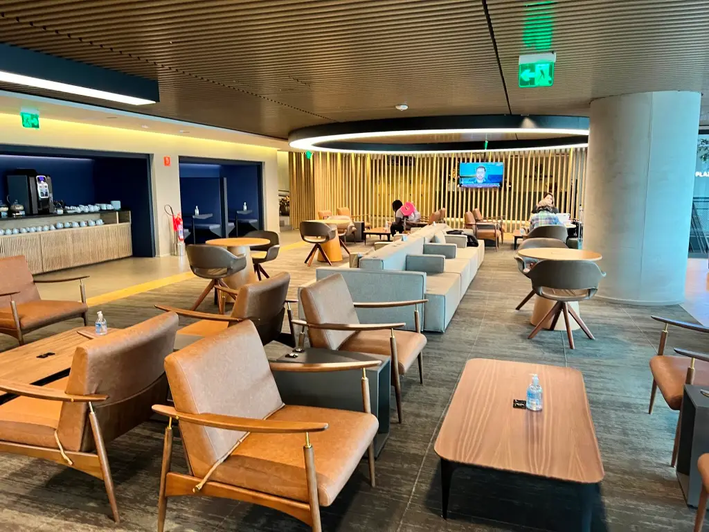 Interior da Plaza Premium Lounge doméstica no Terminal 2 do Aeroporto de Guarulhos com área de descanso, poltronas confortáveis e ambiente premium para passageiros.