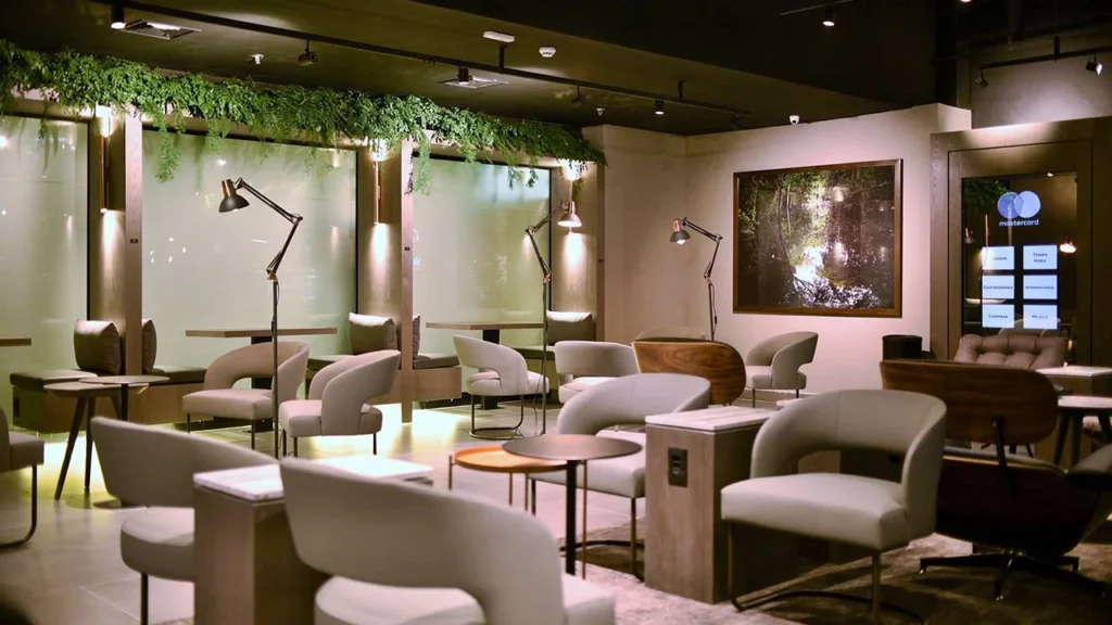Espaço de trabalho da Sala VIP Mastercard Black Lounge no Terminal 3 do Aeroporto de Guarulhos (GRU), com bancadas para notebook, Wi-Fi de alta velocidade, tomadas individuais e ambiente silencioso para passageiros em viagens corporativas.