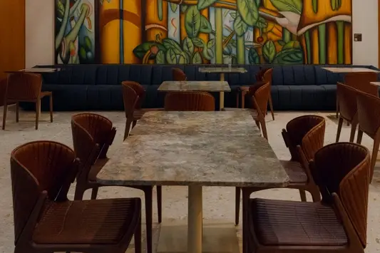 Área de convivência da Sala VIP Pedra Preta do Itaú Personnalité no Terminal 3 do Aeroporto de Guarulhos, com decoração sofisticada e obras de arte.