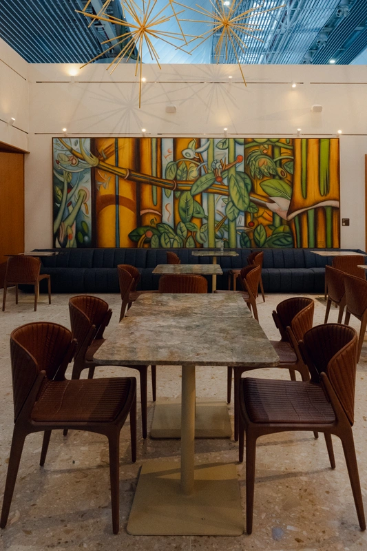 Área de convivência da Sala VIP Pedra Preta do Itaú Personnalité no Terminal 3 do Aeroporto de Guarulhos, com decoração sofisticada e obras de arte.