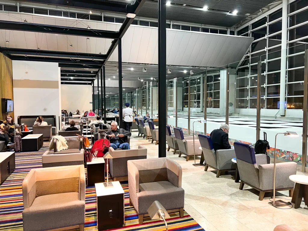 Interior do LATAM Lounge São Paulo no Aeroporto Internacional de Guarulhos (GRU), com área de descanso, poltronas premium e vista para o terminal de embarque internacional.