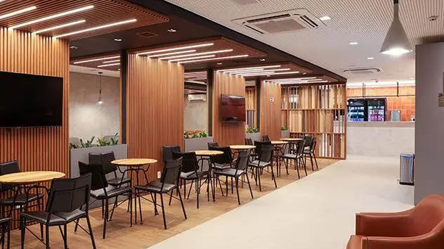 Interior do Advantage VIP Lounge no Aeroporto de Congonhas (CGH), em São Paulo, com área de descanso, mesas e espaço para refeições.
