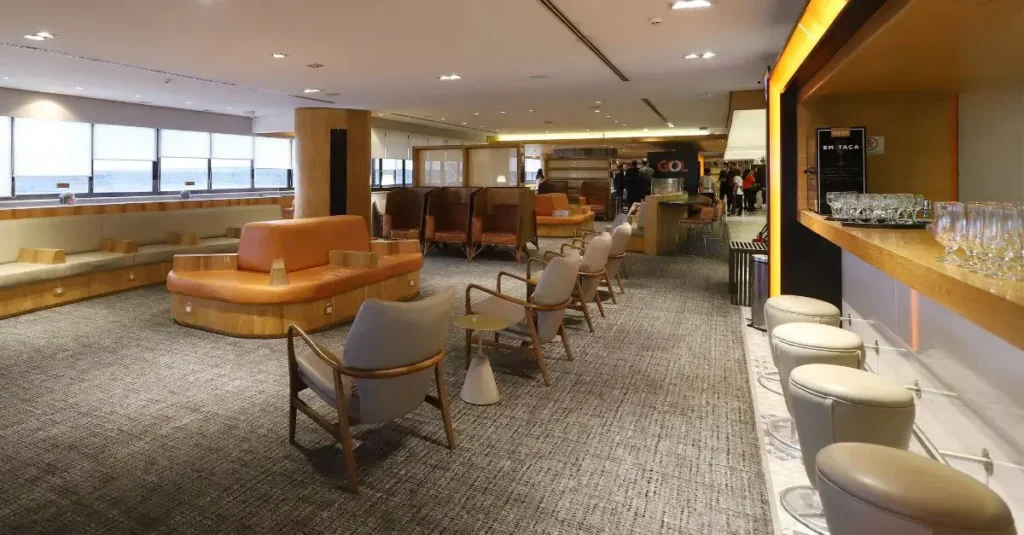 Interior da Sala VIP GOL Smiles Internacional no Terminal 2 do Aeroporto de Guarulhos (GRU), com poltronas, área de descanso e bar para passageiros de voos internacionais.